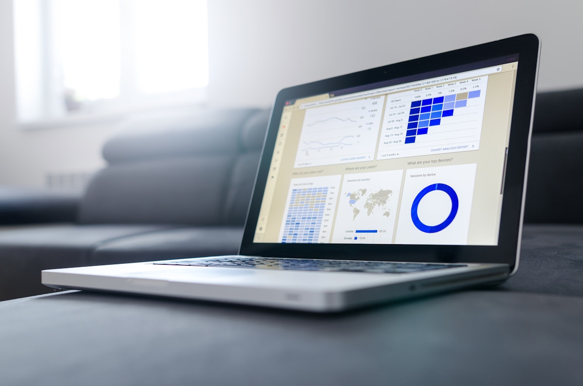 Laptop affichant Google Analytics avec courbes de trafic et rapport de positionnement SEO