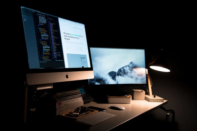 Double écran de développement web affichant du code et une interface de site pour artisan